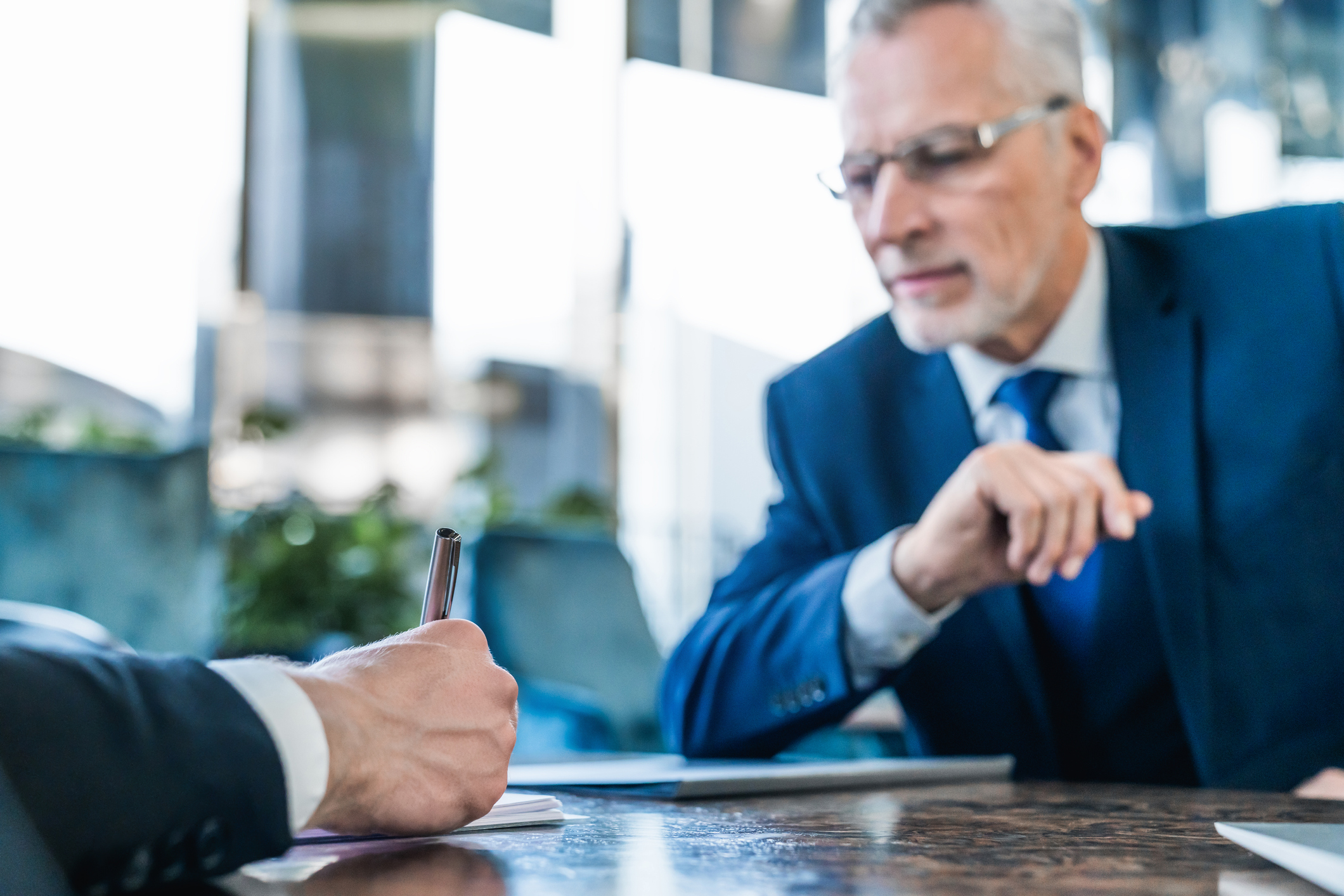 Businessman signing agreement, senior man in suit with company contract