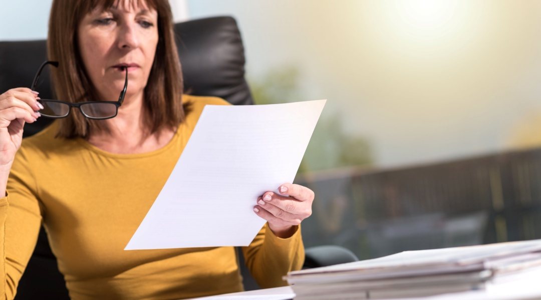 Letter of intent, represented by businesswomen reading document.