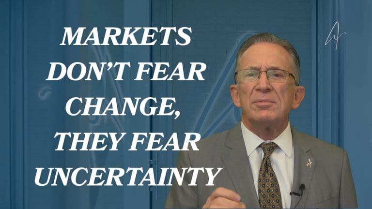 Man in suit and glasses discussing financial markets, with text Markets Don't Fear Change, They Fear Uncertainty.